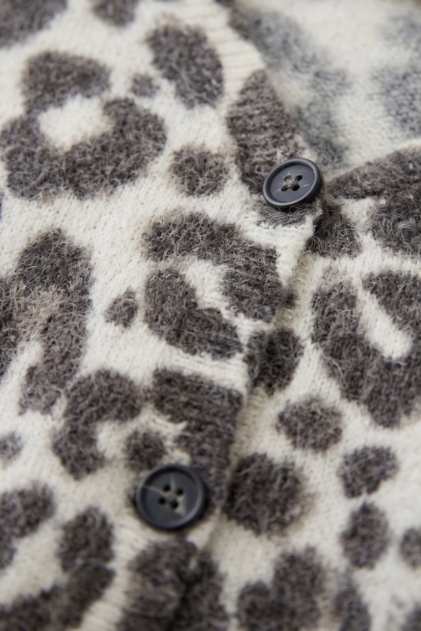 Leopard print cardigan with black buttons, soft texture, perfect for casual wear.