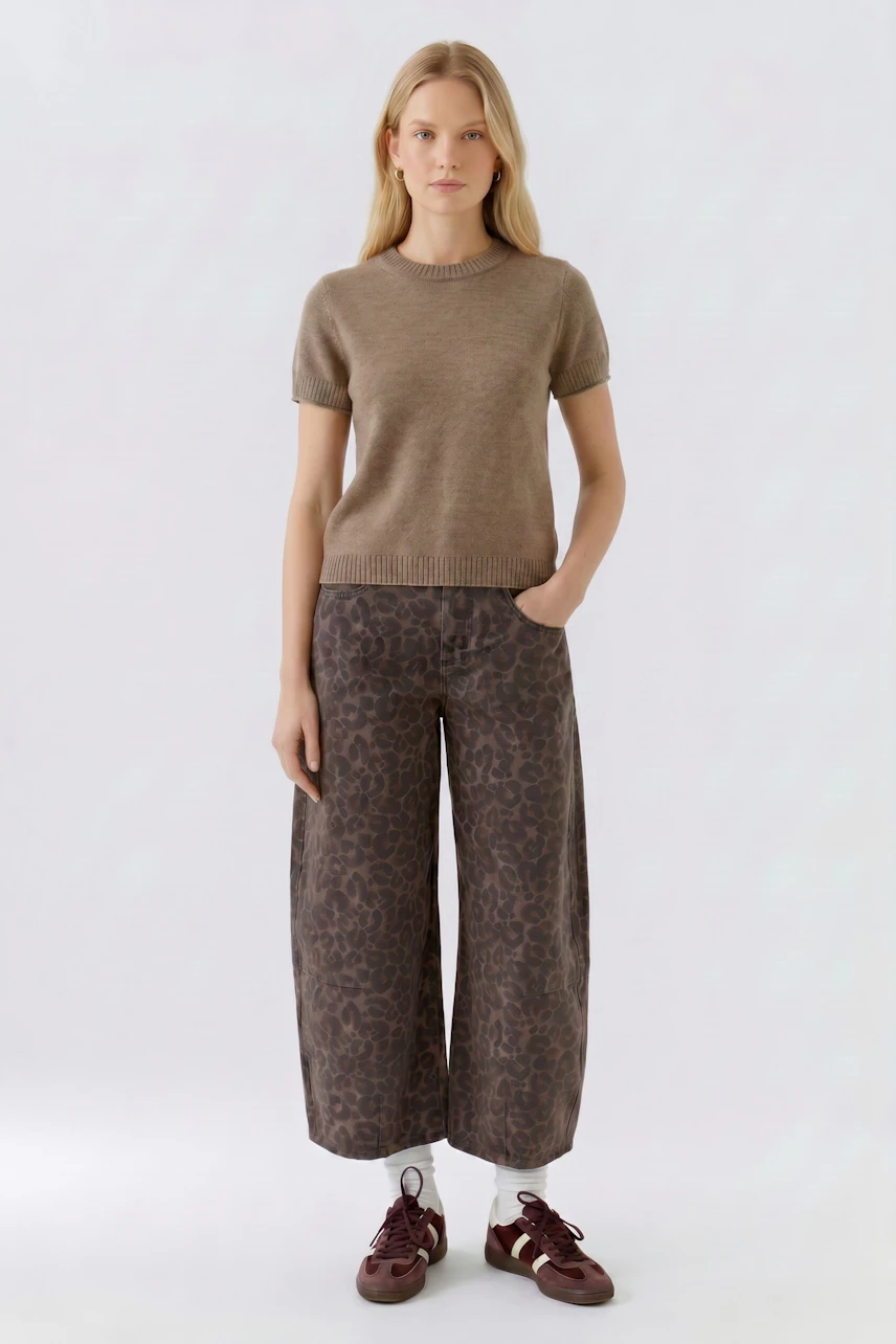 Damen-Pullover: Frau im braunen Pullover mit kurzen Ärmeln und gemusterten Hosen, lässig und modern.
