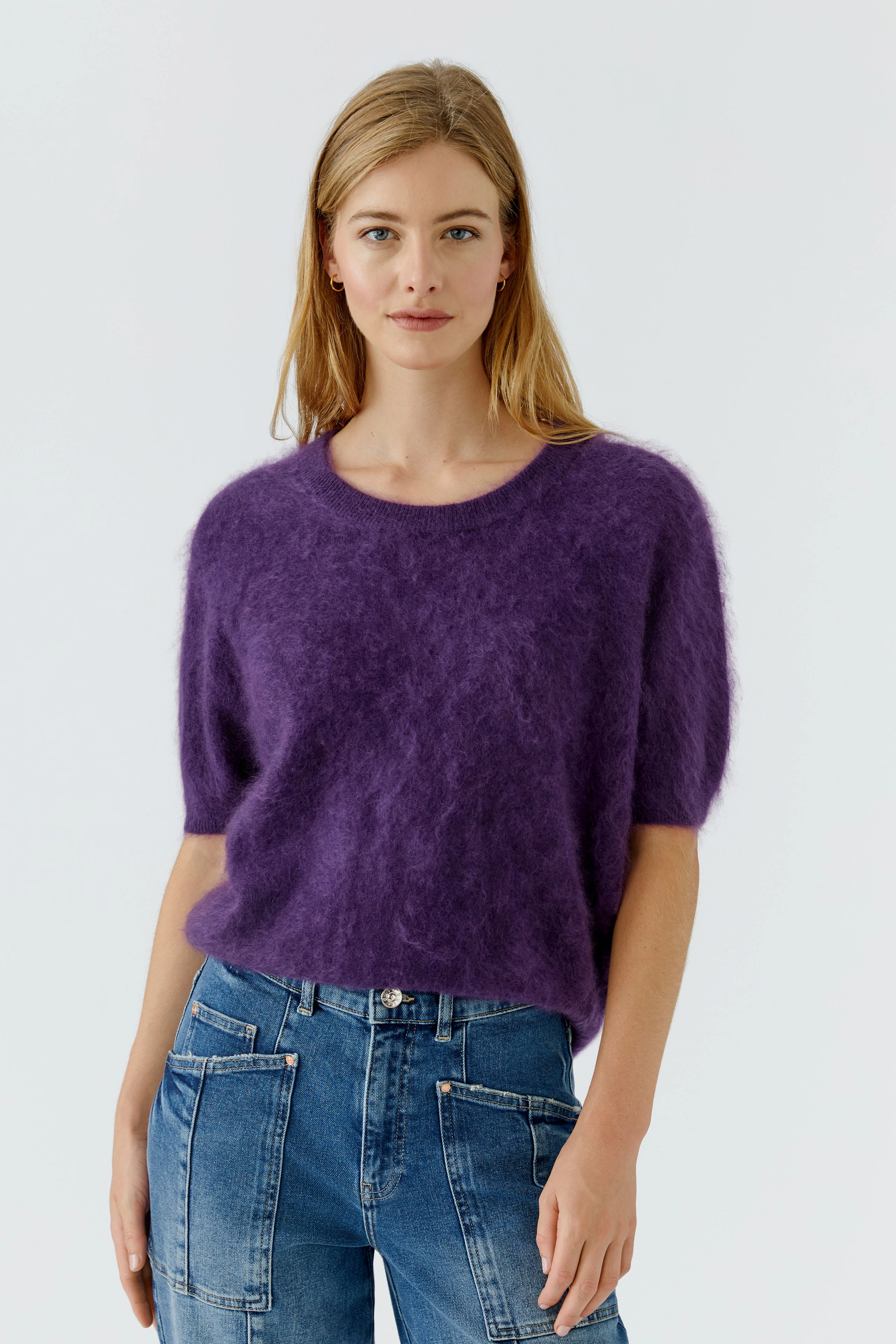 Lässiger Damen-Pullover: Frau im flauschigen lila Pullover und Jeans, entspannt und modisch.