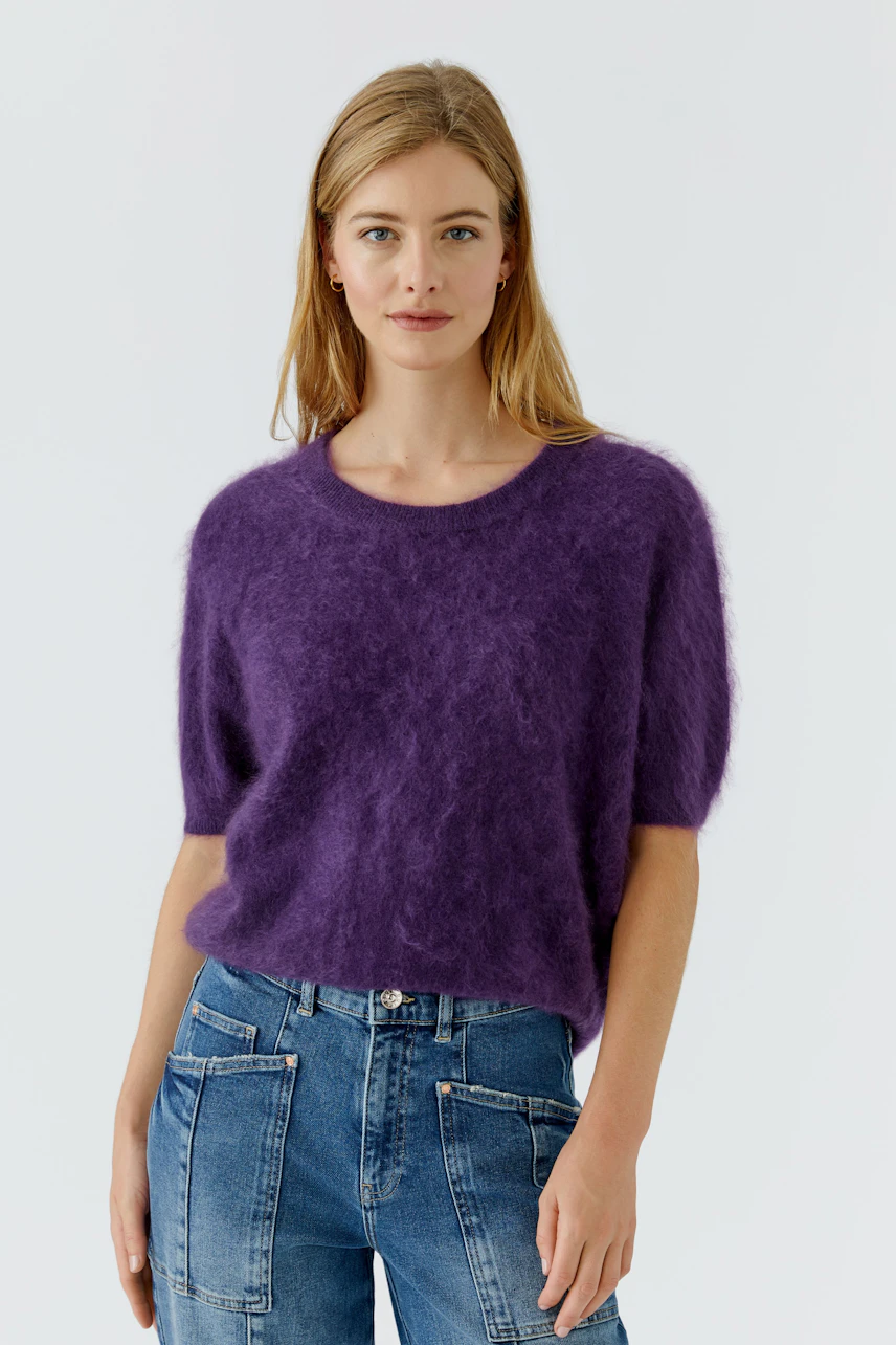 Lässiger Damen-Pullover: Frau im flauschigen lila Pullover und Jeans, entspannt und modisch.