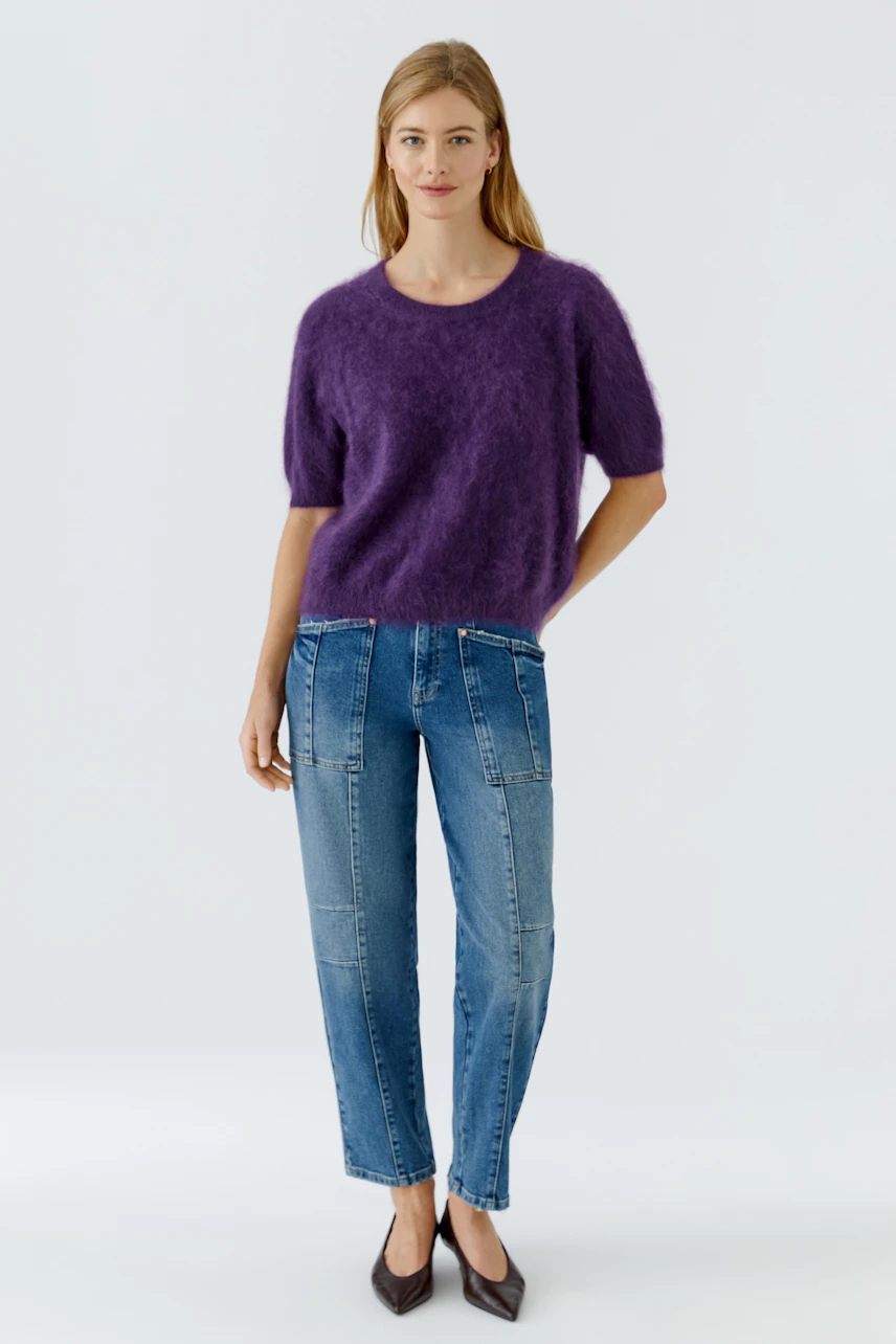 Lässiger Damen-Pullover: Frau im flauschigen lila Pullover und Jeans, entspannt und modisch.