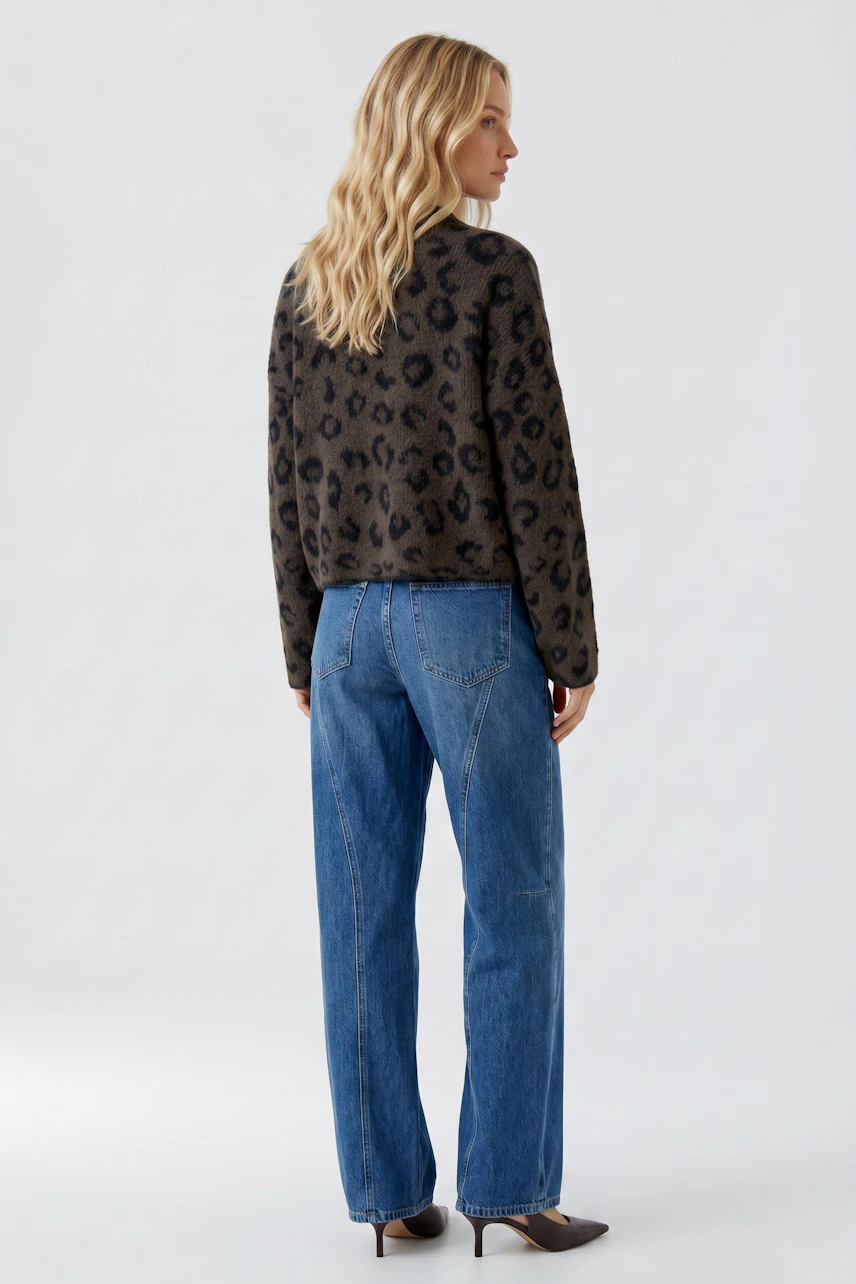 Lässiger Damen-Pullover: Frau im Leopardenmuster-Pullover und blauen Jeans von hinten zu sehen.