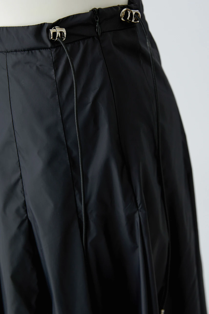 Black A-line skirt with buckle details, shown on a mannequin. Simple and versatile design.