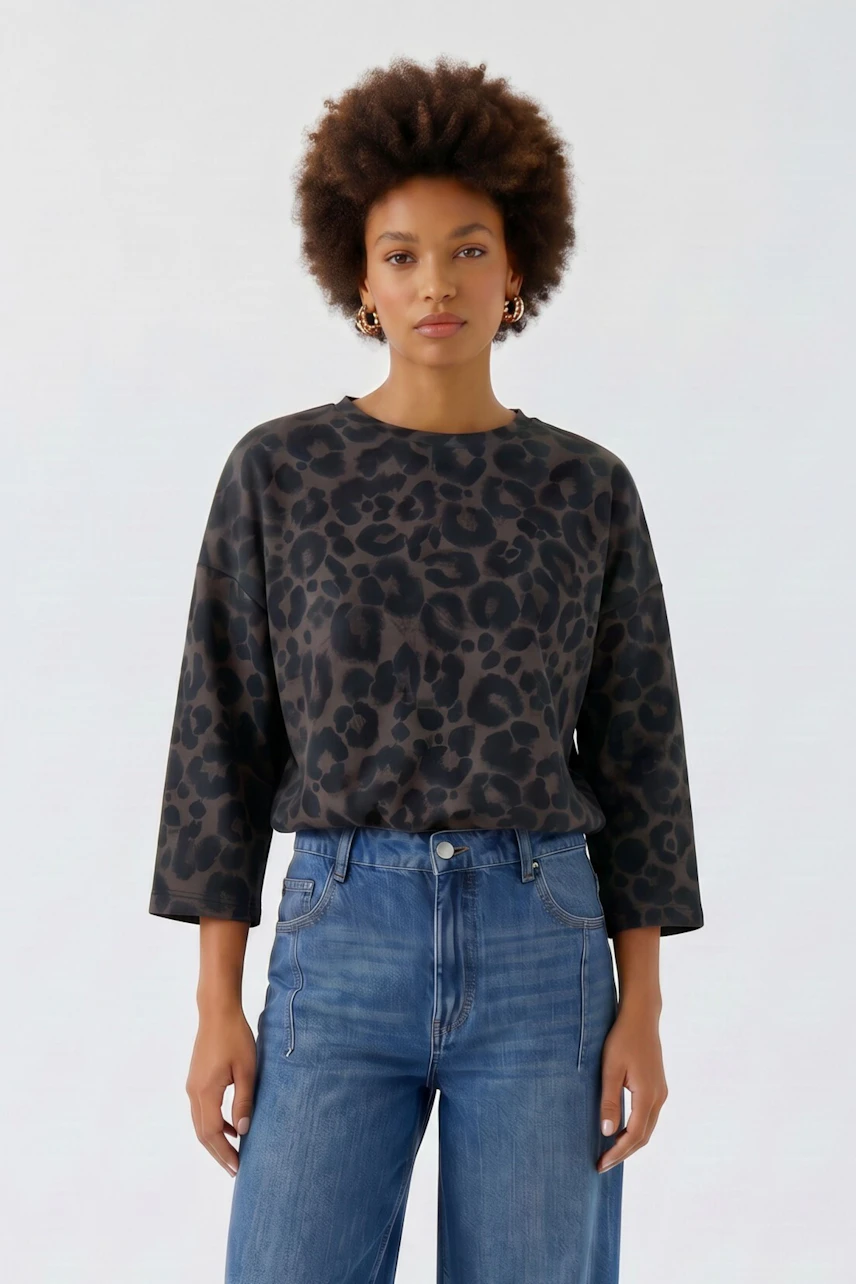 Lässiges Damen-Sweatshirt: Frau im schwarzen Sweatshirt mit Leopardenmuster und blauer Jeans.