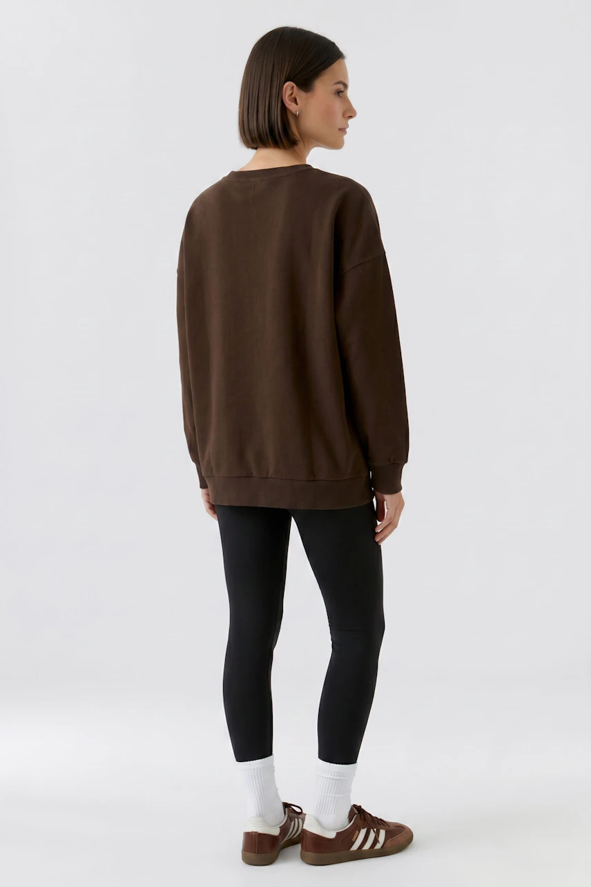 Lässiges Damen-Sweatshirt: Frau im braunen Sweatshirt und passender Hose, von hinten gesehen.