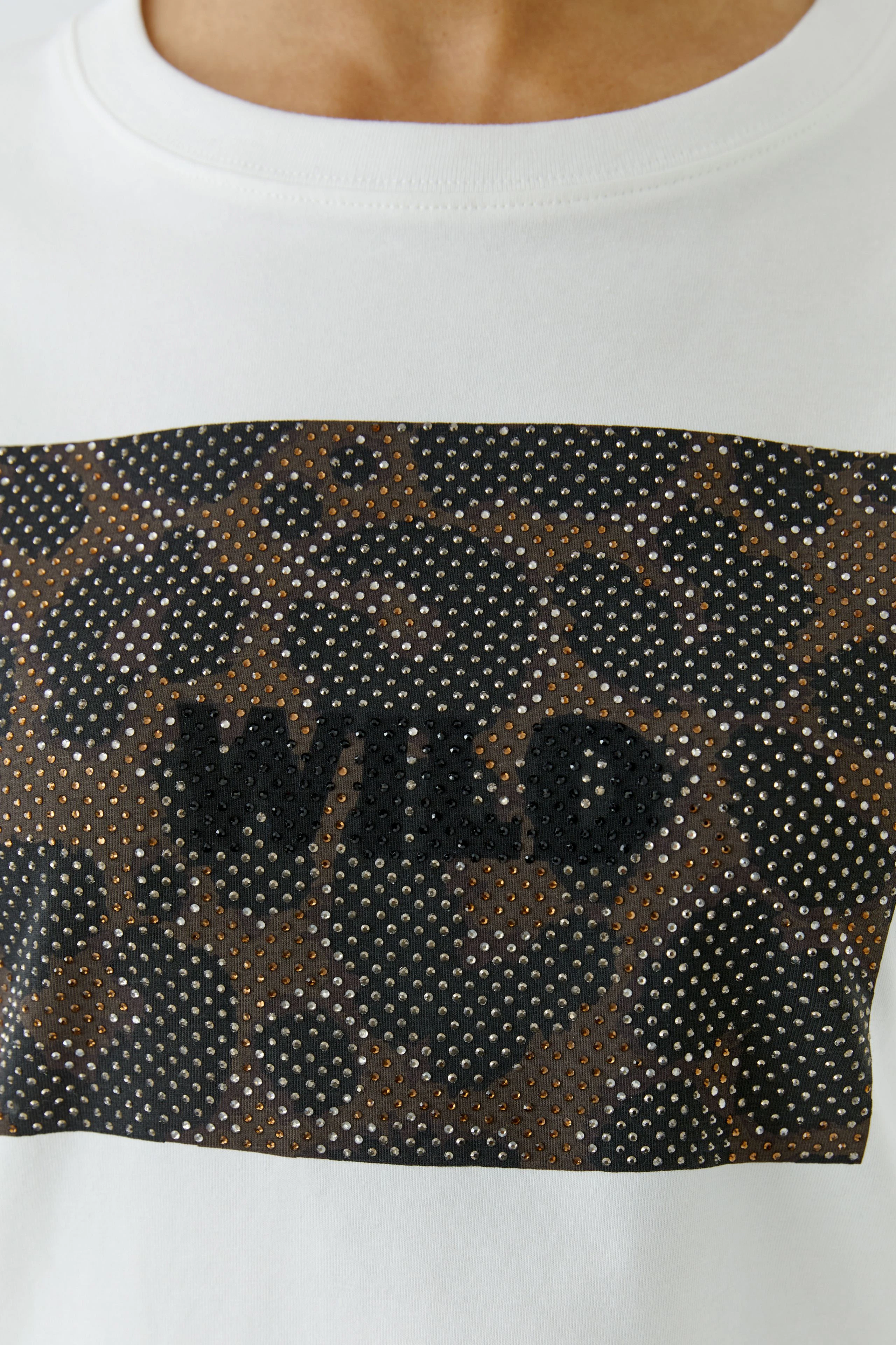 Weißes Damen-T-Shirt: Frau trägt T-Shirt mit "WILD"-Print und Leopardenmuster-Detail.
