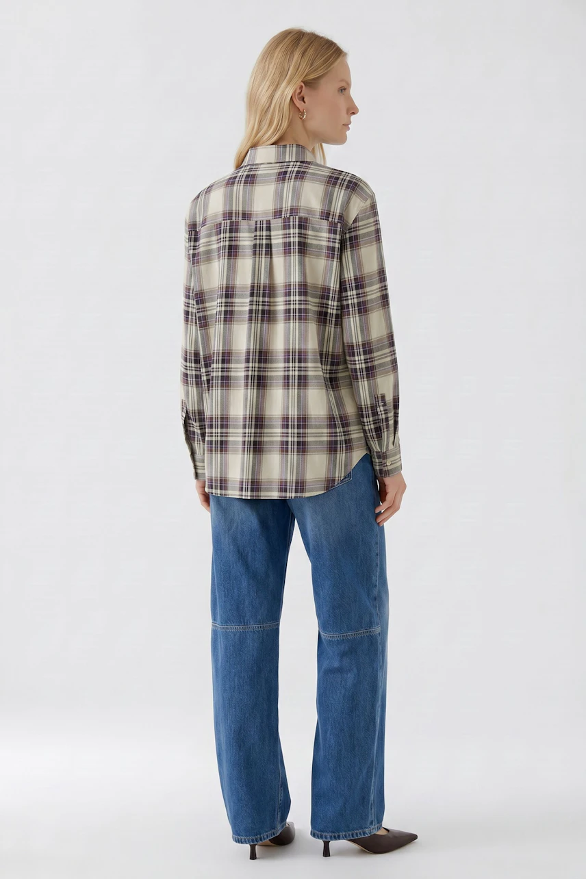 Frau in karierter Schluppenbluse und blauen Jeans, Rückansicht. Lässiger Look für den Alltag.