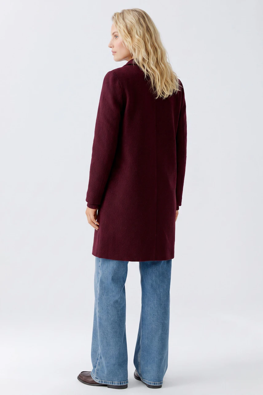 Stylish women's wool coat in burgundy, paired with wide-leg jeans, showcasing a modern look.