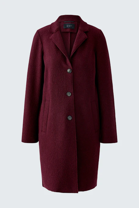Wool coat: A woman in a burgundy wool coat with a classic collar and button closure.