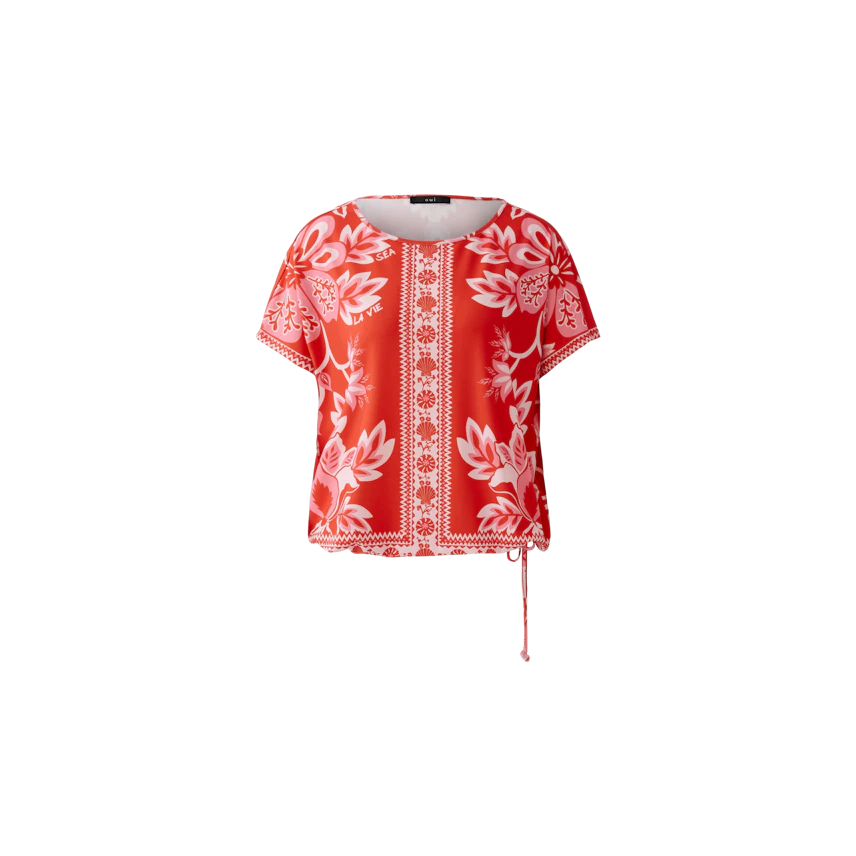 Casual women's T-shirt: A woman in a vibrant red floral top with a relaxed fit and side tie detail.