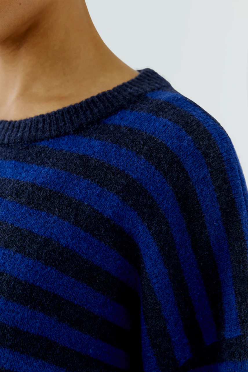 Striped pullover: Woman in a blue and black striped pullover, close-up of the upper body.