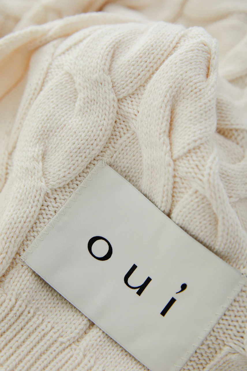Cozy knit scarf with cable pattern, perfect for layering. Soft texture and neutral color for versatile styling.
