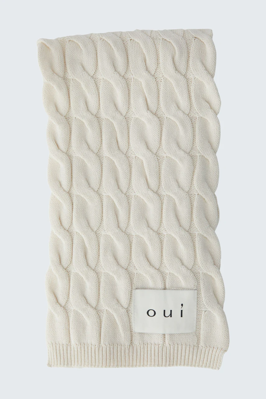 Cozy knit scarf in cream with a textured pattern, perfect for adding warmth and style to any outfit.