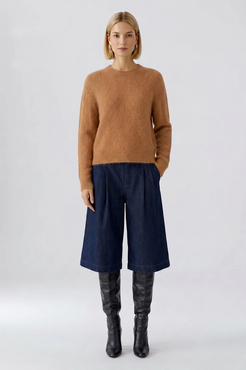Damen-Pullover: Frau im braunen Pullover, kombiniert mit blauen Culottes und schwarzen Stiefeln.