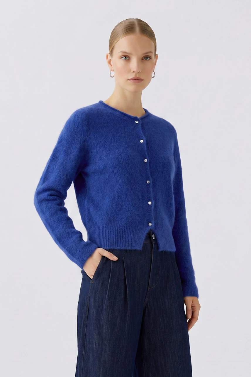 Woman in blue cardigan: Model wears a blue button-up cardigan with dark pants, looking forward.