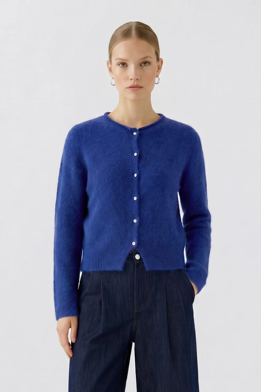 Woman in blue cardigan: Model wears a blue button-up cardigan with dark pants, looking forward.