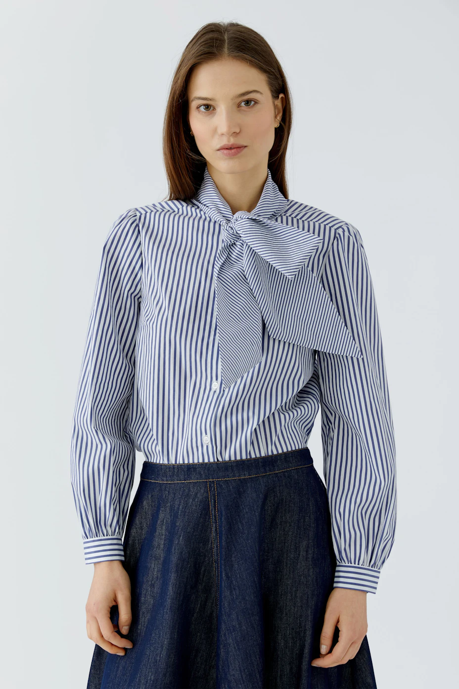 Striped pussy-bow blouse: Blue and white stripes with a large bow, perfect for a chic, casual look.