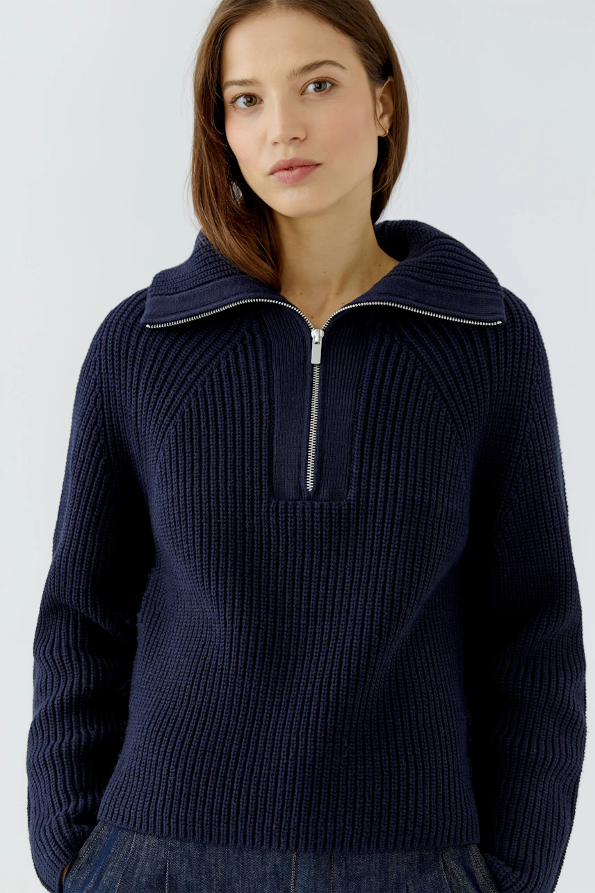 Woman in navy pullover with zip collar, casual and stylish look.