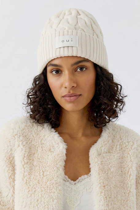 Strickmütze in Creme: Weiche, gerippte Mütze mit Oui-Logo für stilvolle Wärme.