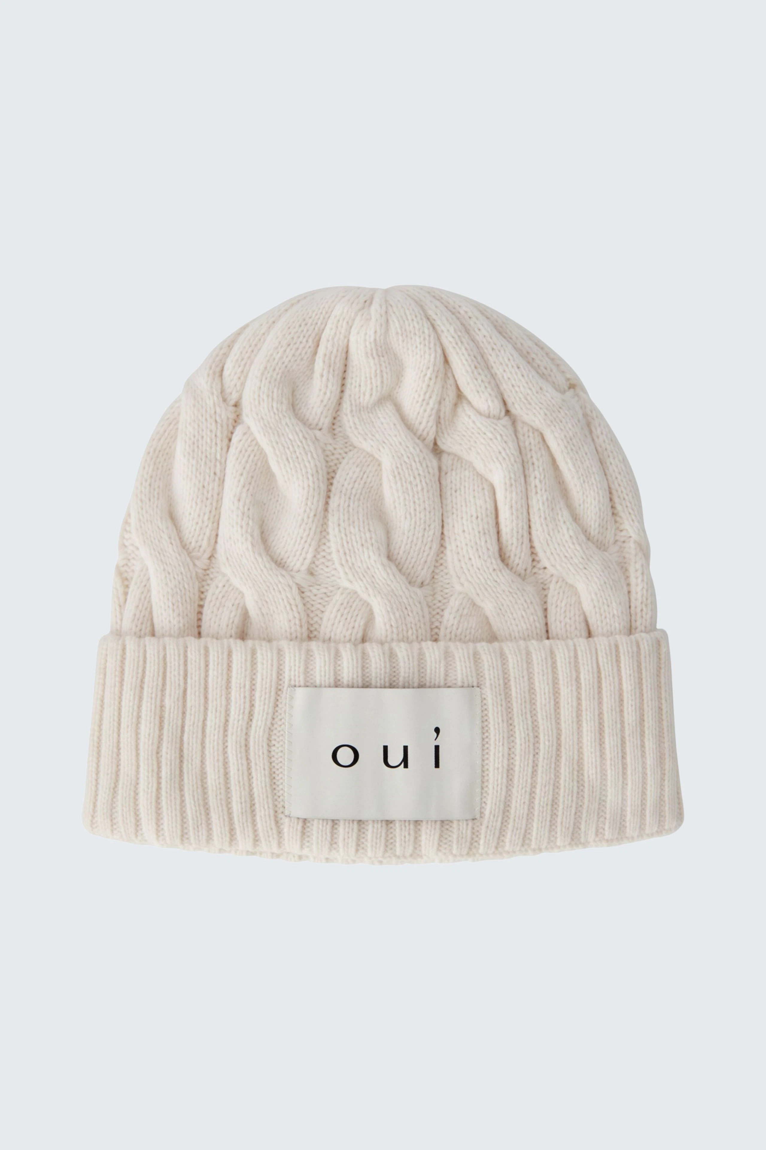 Cozy knit hat: Cream cable-knit beanie with "oui" logo, perfect for chilly days.