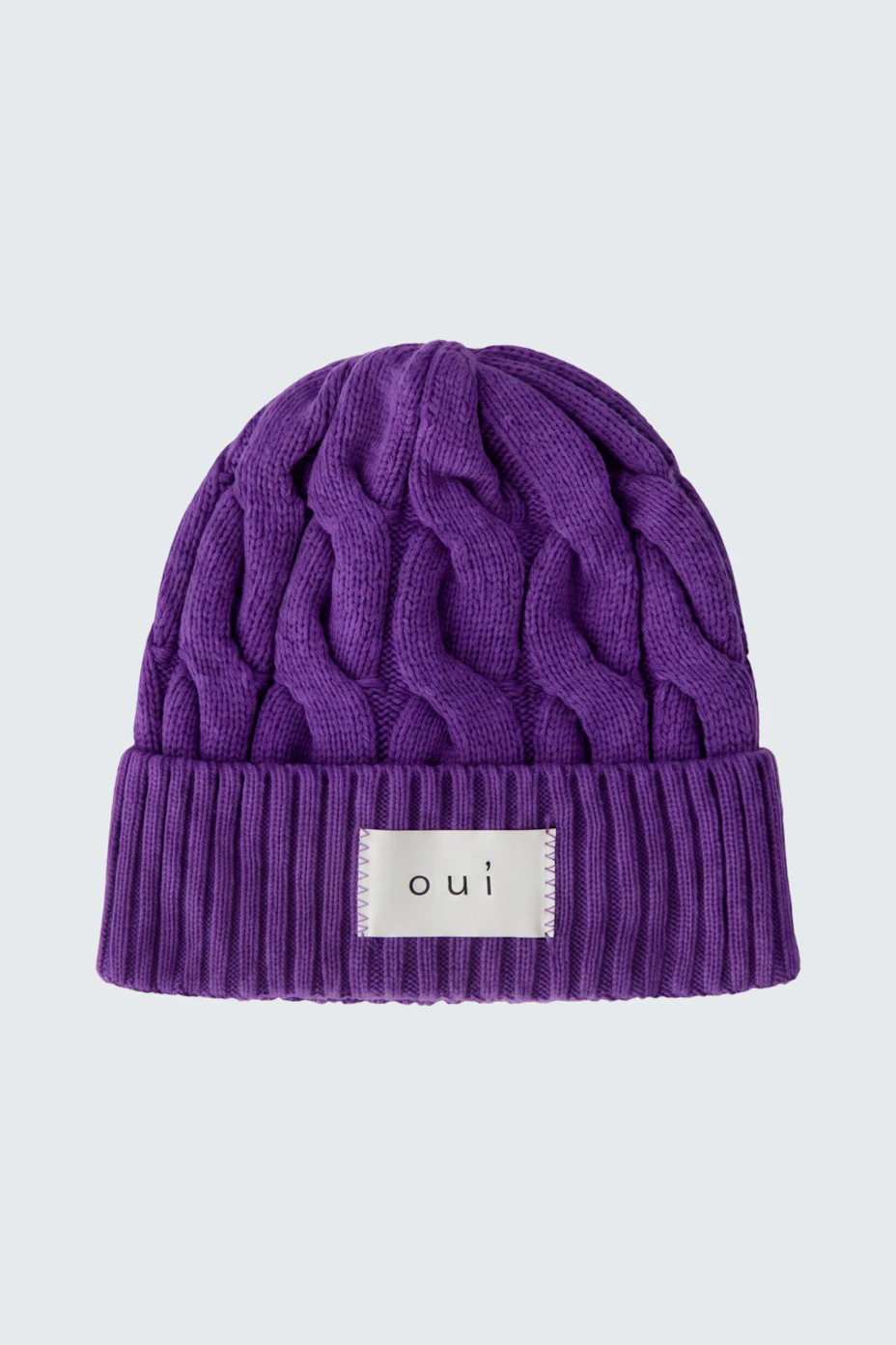 Lila Strickmütze von Oui mit Zopfmuster und Logo-Patch, ideal für kalte Tage.