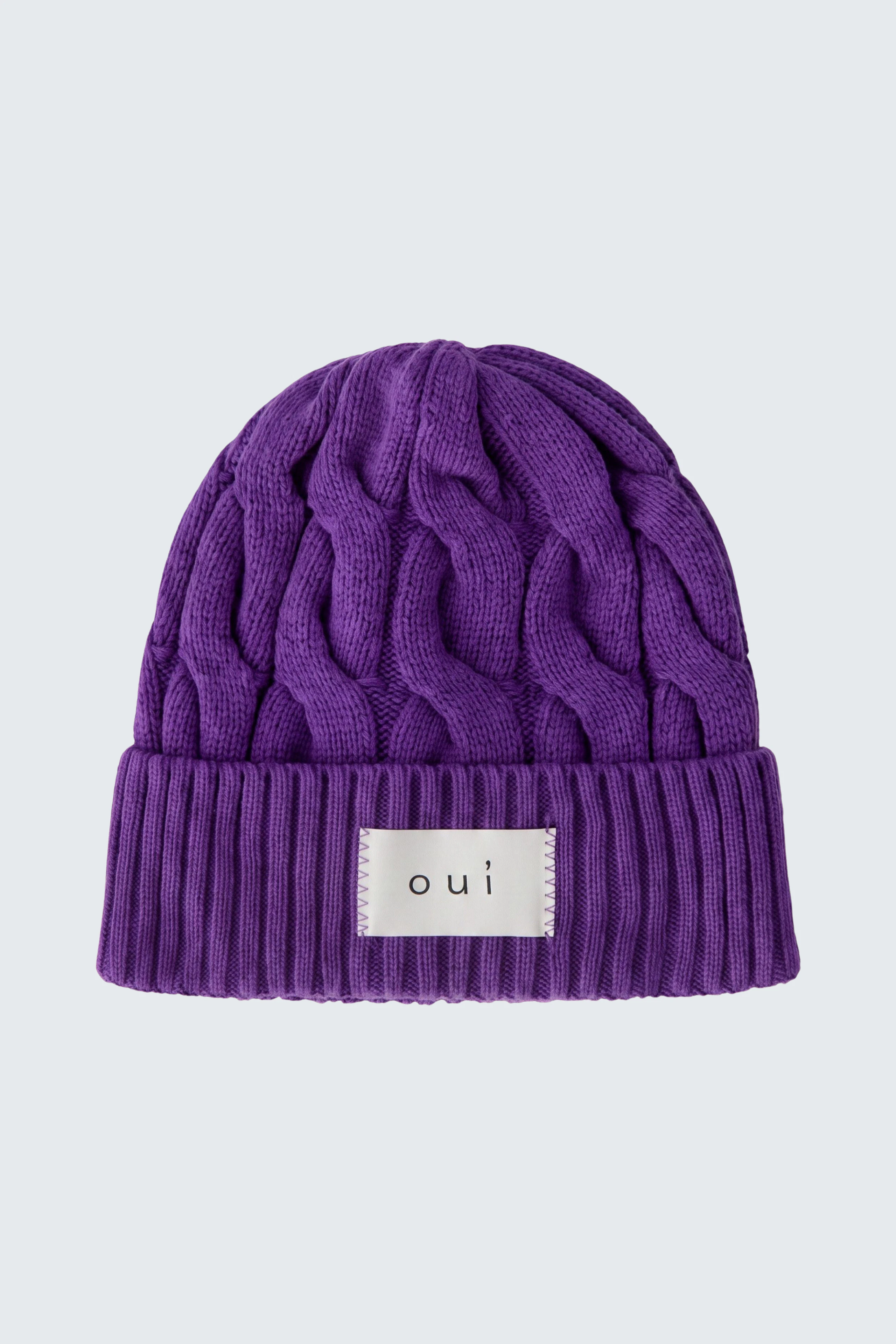 Lila Strickmütze von Oui mit Zopfmuster und Logo-Patch, ideal für kalte Tage.