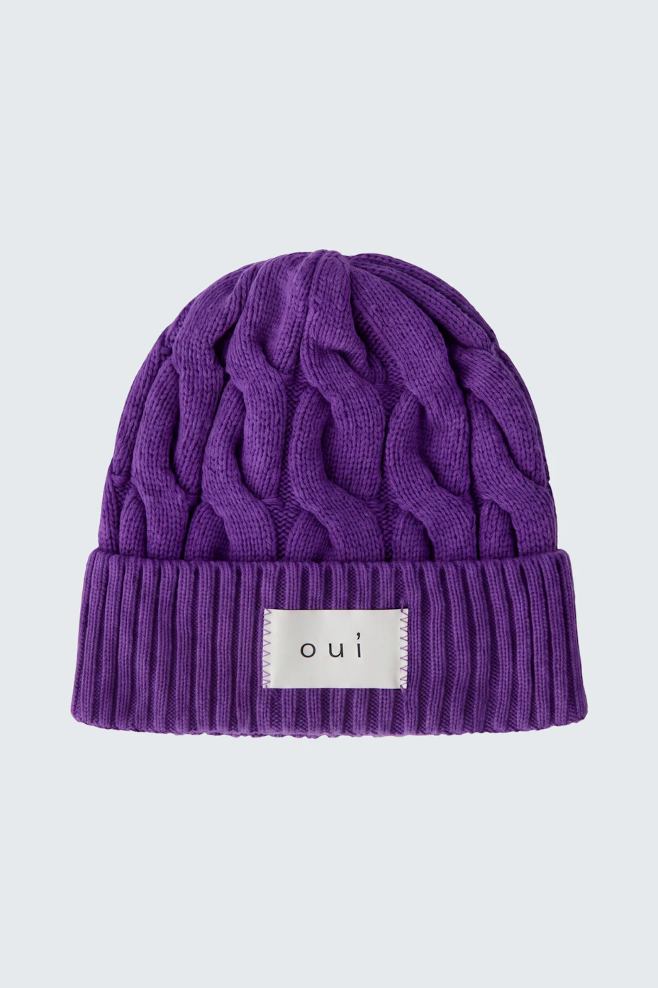 Lila Strickmütze von Oui mit Zopfmuster und Logo-Patch, ideal für kalte Tage.