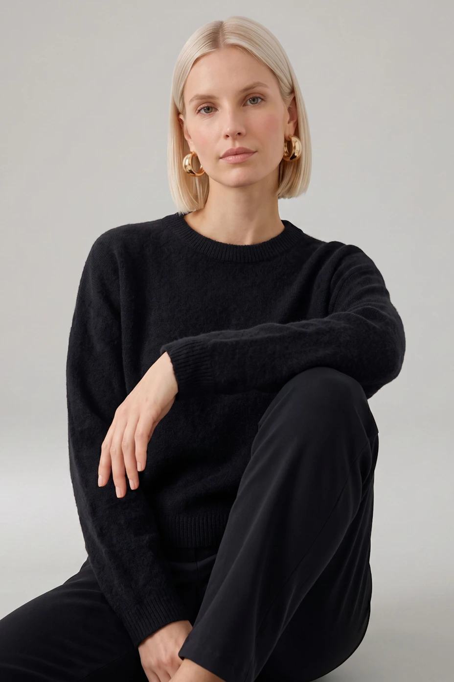 Casual women's pullover in soft black fabric, featuring a relaxed fit and round neckline.