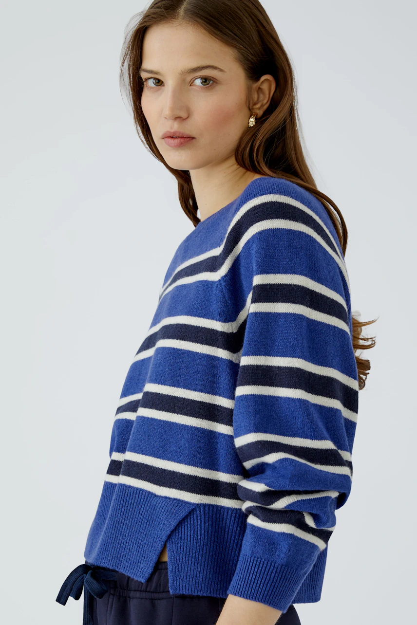 Woman in a blue striped pullover, looking confidently. Casual and stylish design for everyday wear.