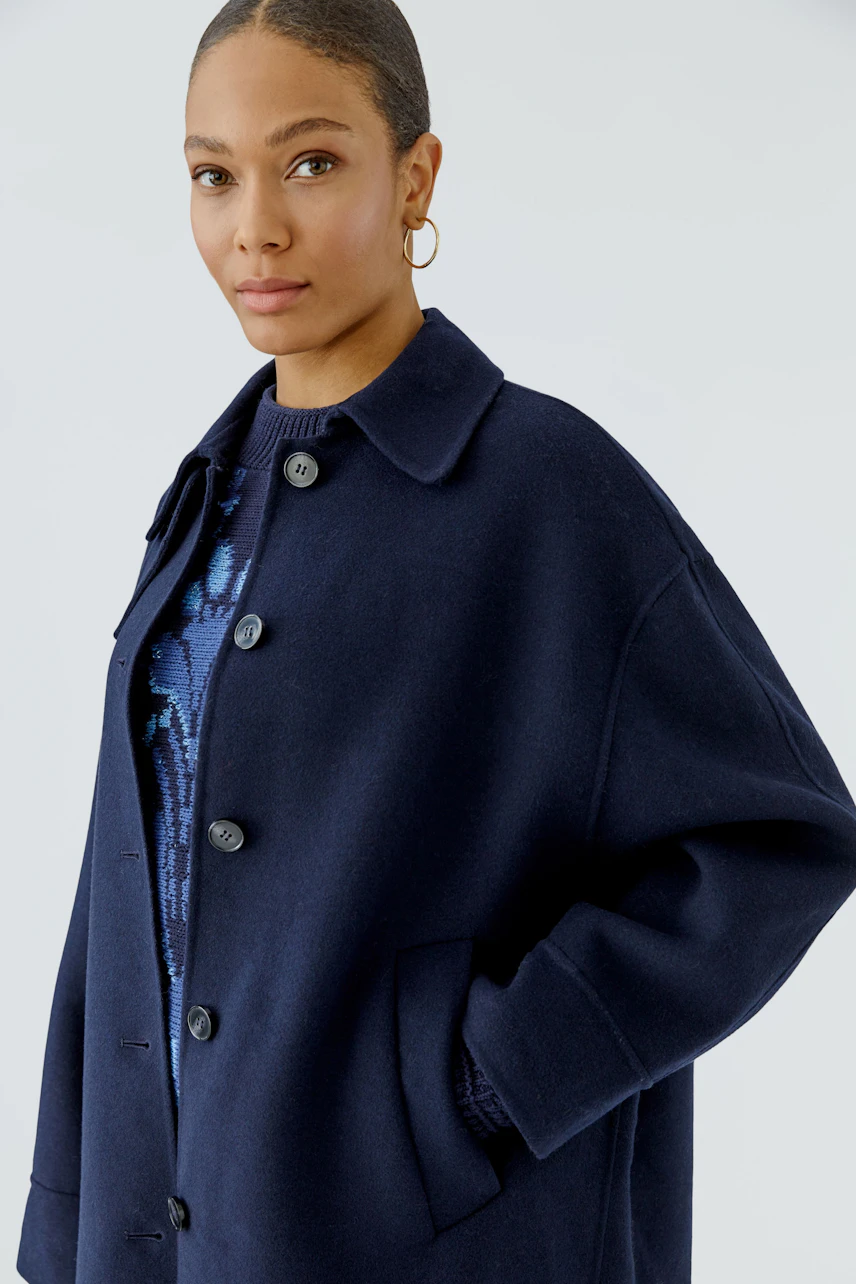 Woman in navy wool coat: Casual style with button-up front, perfect for cool weather.