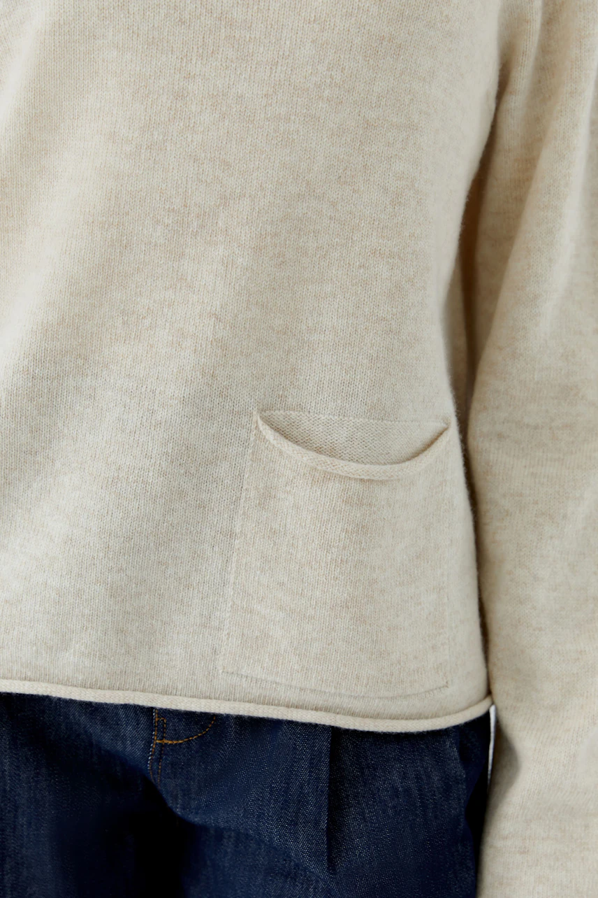 Casual pullover: Beige pullover with a small pocket, paired with dark jeans, no model visible.