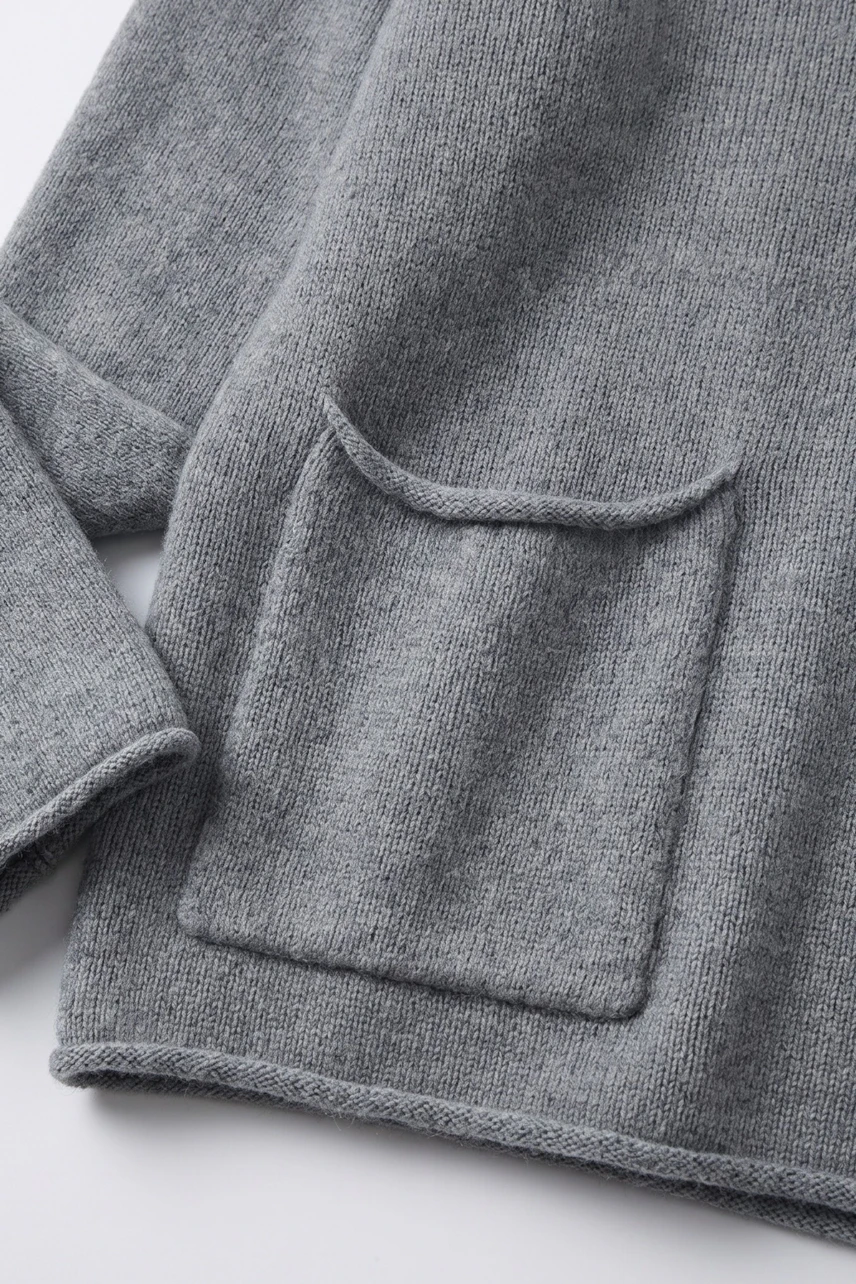 Casual grey pullover with a front pocket, showcasing soft knit texture. Ideal for a relaxed, cozy look.
