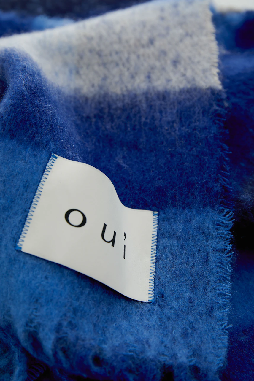 Weicher Schal in Blau-Weiß mit Oui-Label, ideal für kühle Tage. Perfekt für modische Akzente.