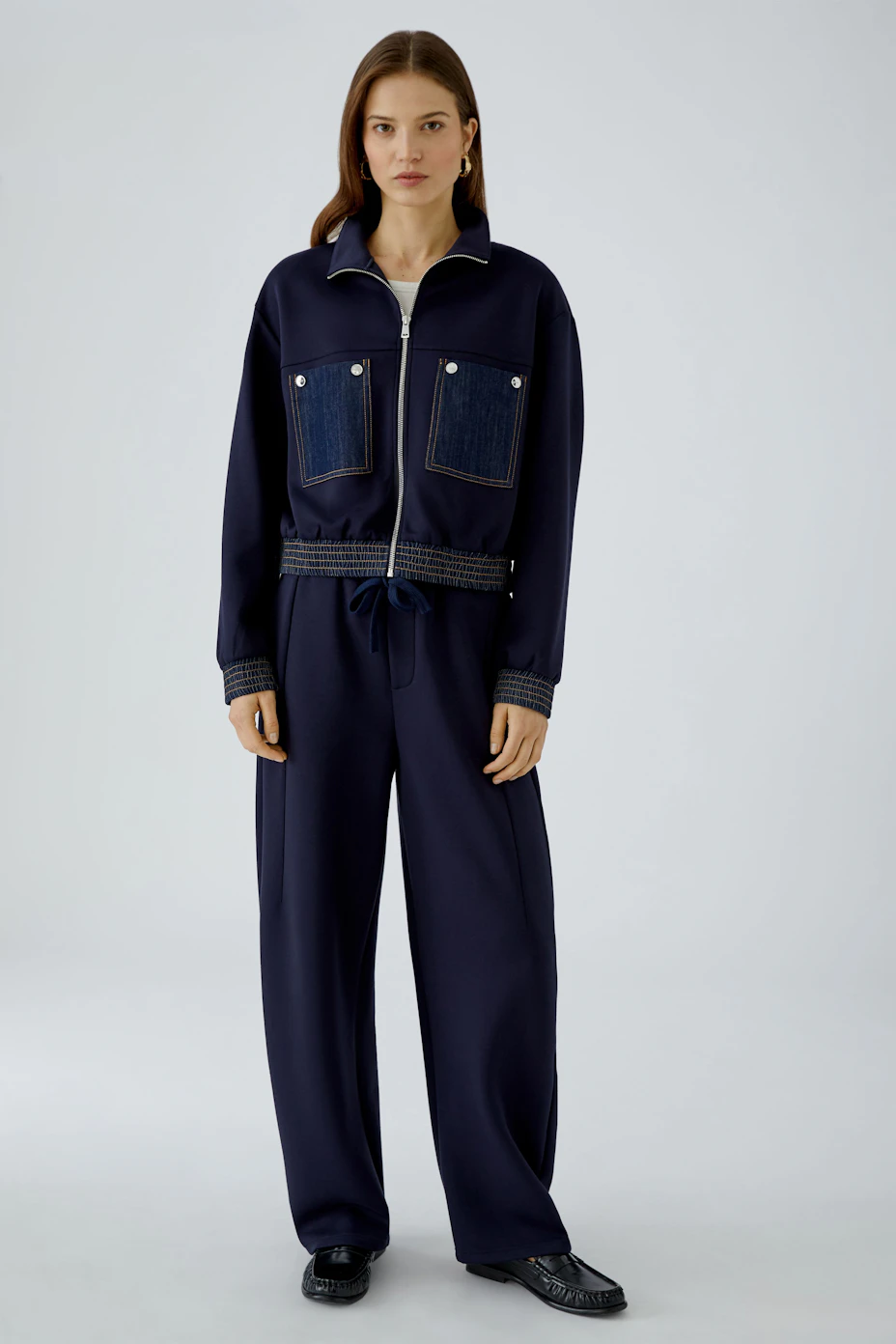 Navy blouson with denim pockets, zip closure, and ribbed cuffs. Casual and versatile for everyday wear.