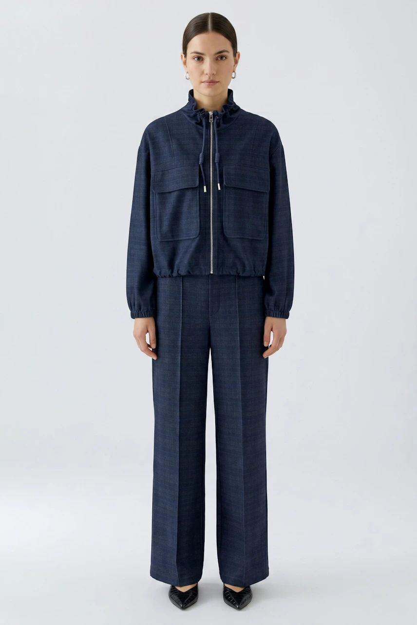 Woman in blue wide-leg pants and matching jacket, standing confidently. Casual and stylish look.