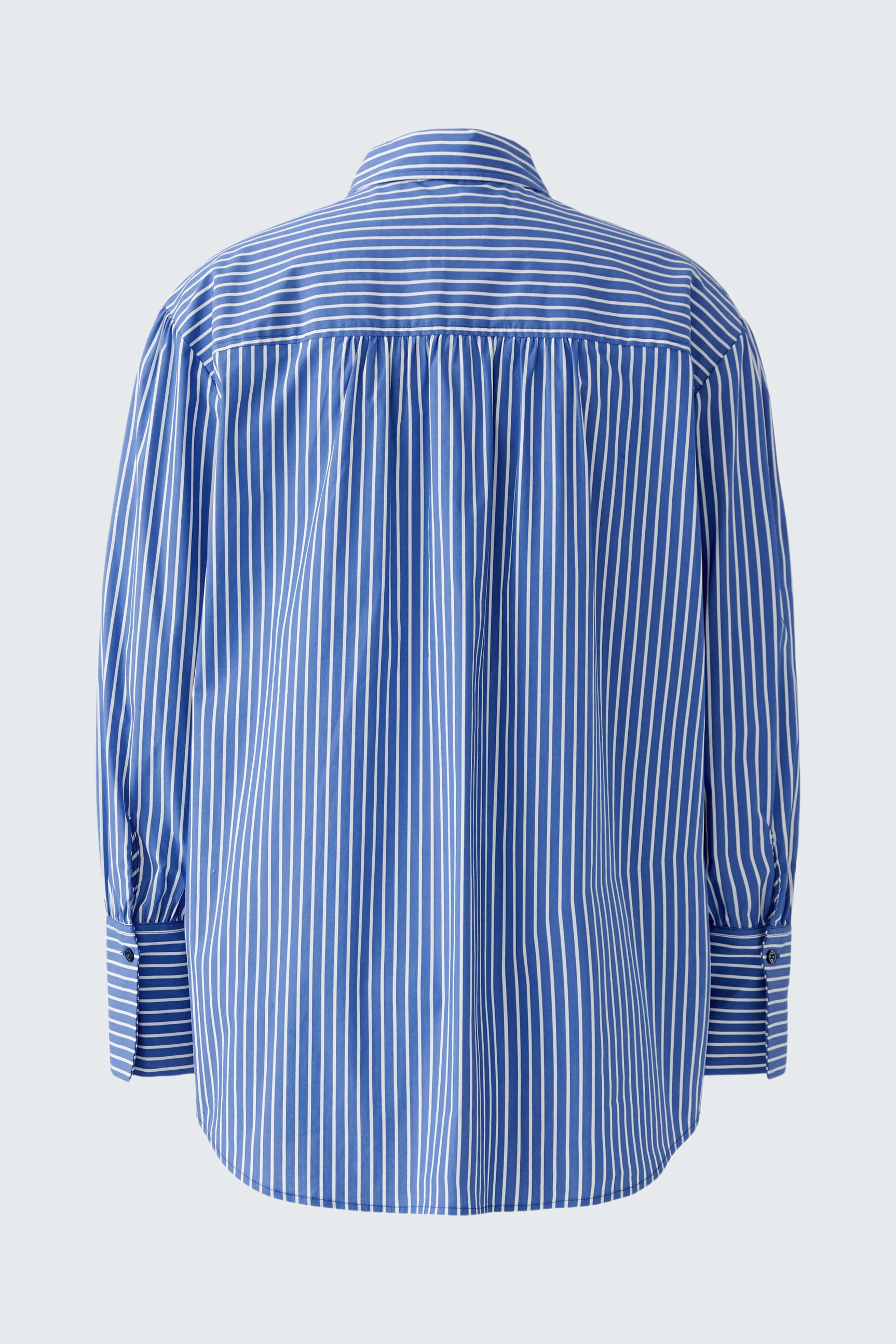 Striped women's shirt blouse in blue and white, shown from the back, highlighting its relaxed fit.