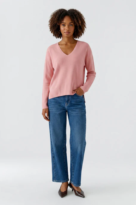 Casual pink pullover with V-neck, displayed on a hanger, showcasing soft fabric and relaxed fit.