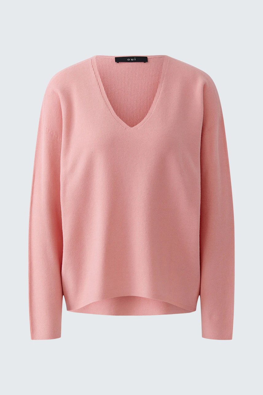 Casual pink pullover with V-neck, displayed on a hanger, showcasing soft fabric and relaxed fit.