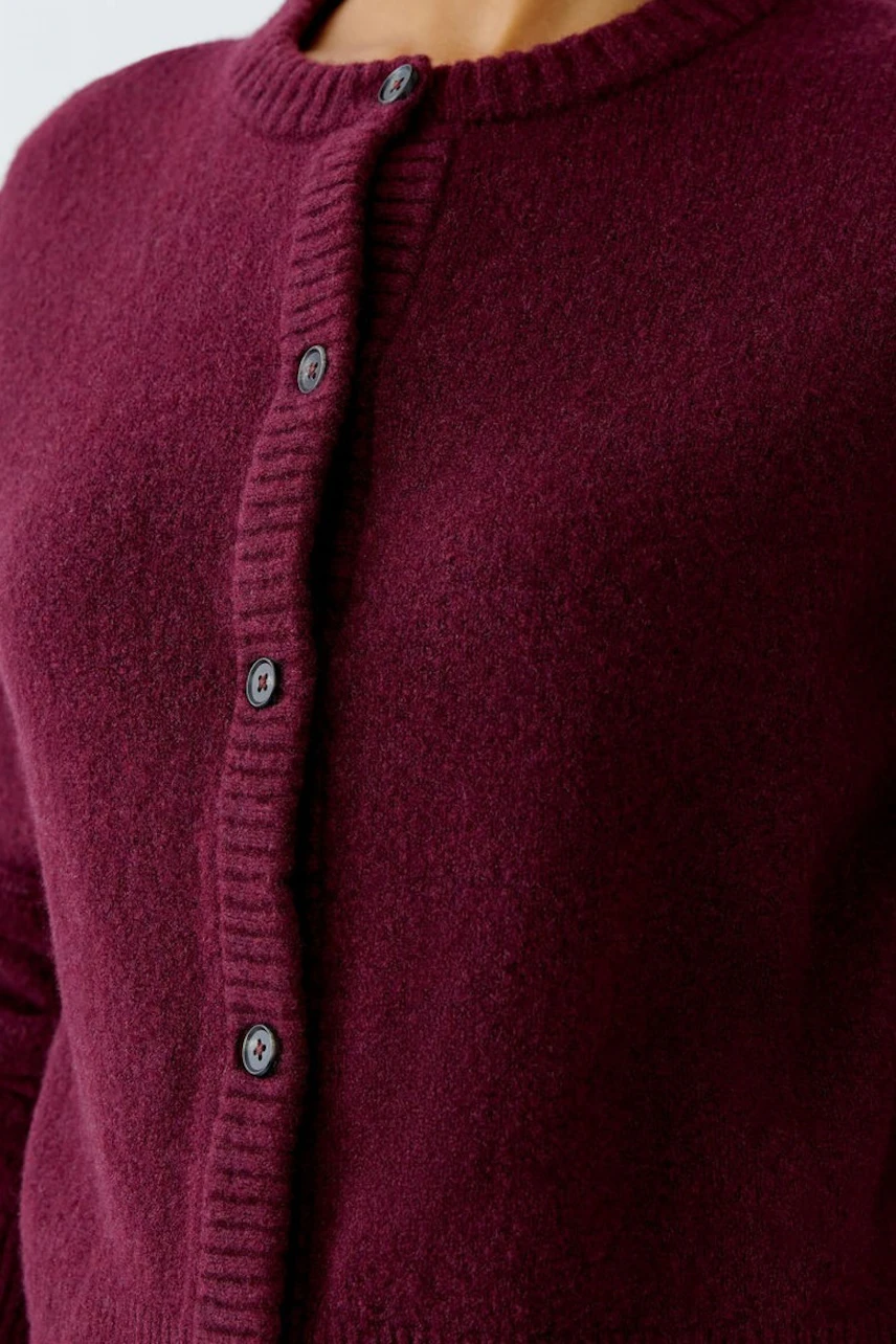Bordeauxrote Strickjacke: Detailaufnahme des weichen Materials mit Knopfleiste, ohne Model.