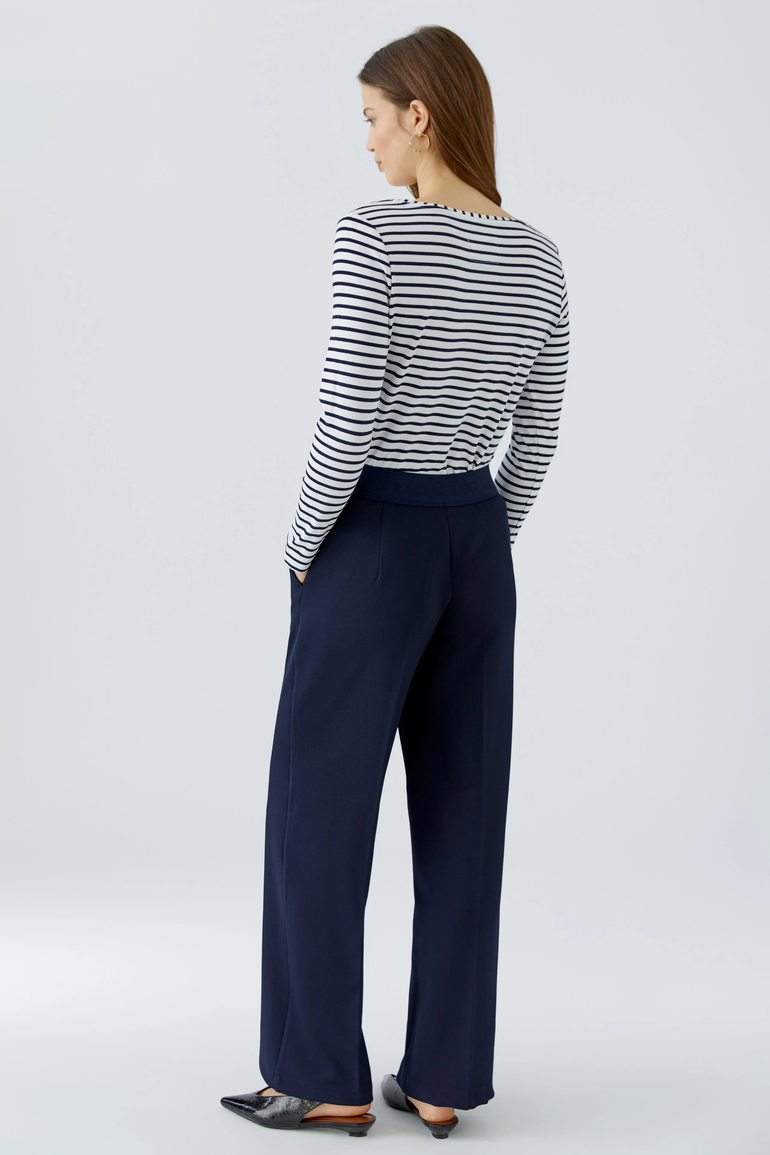 Casual women's trousers: A woman in navy trousers with a relaxed fit, showcasing a simple and modern style.