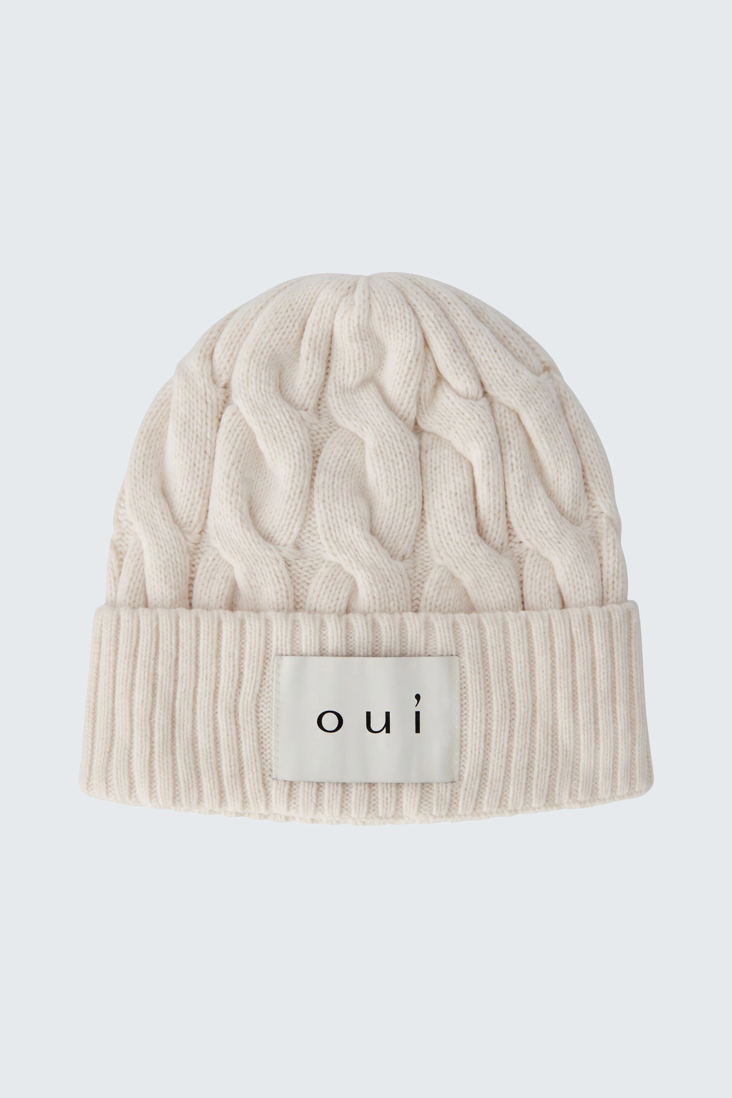 Cozy knit hat: Cream cable-knit beanie with "oui" logo, perfect for chilly days.