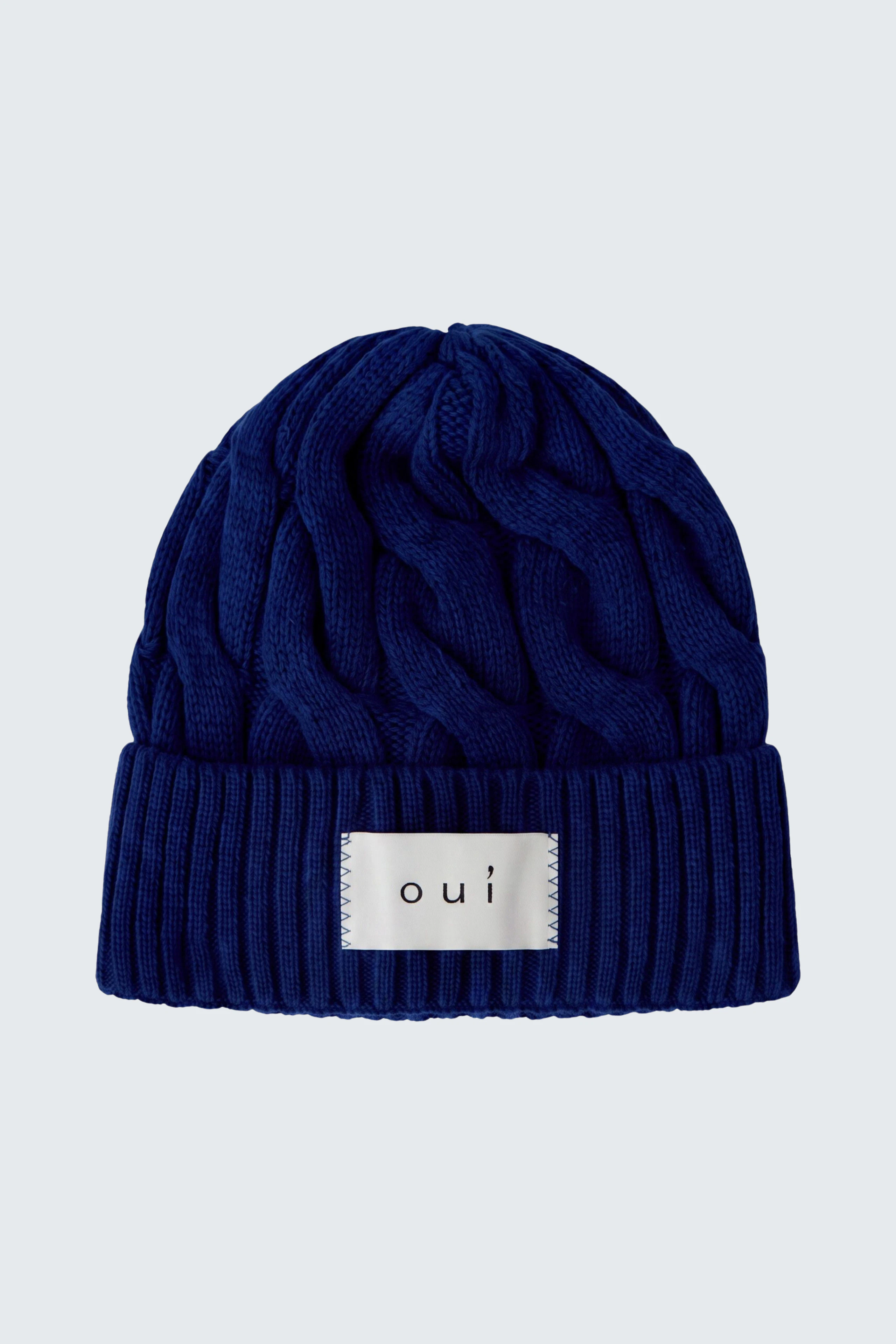 Blaue Strickmütze von Oui: Weiches Material mit Zopfmuster und Logo-Patch, ideal für kalte Tage.