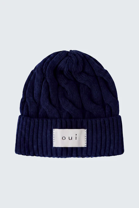 Dunkelblaue Strickmütze mit Zopfmuster und Oui-Logo, ideal für kalte Tage.