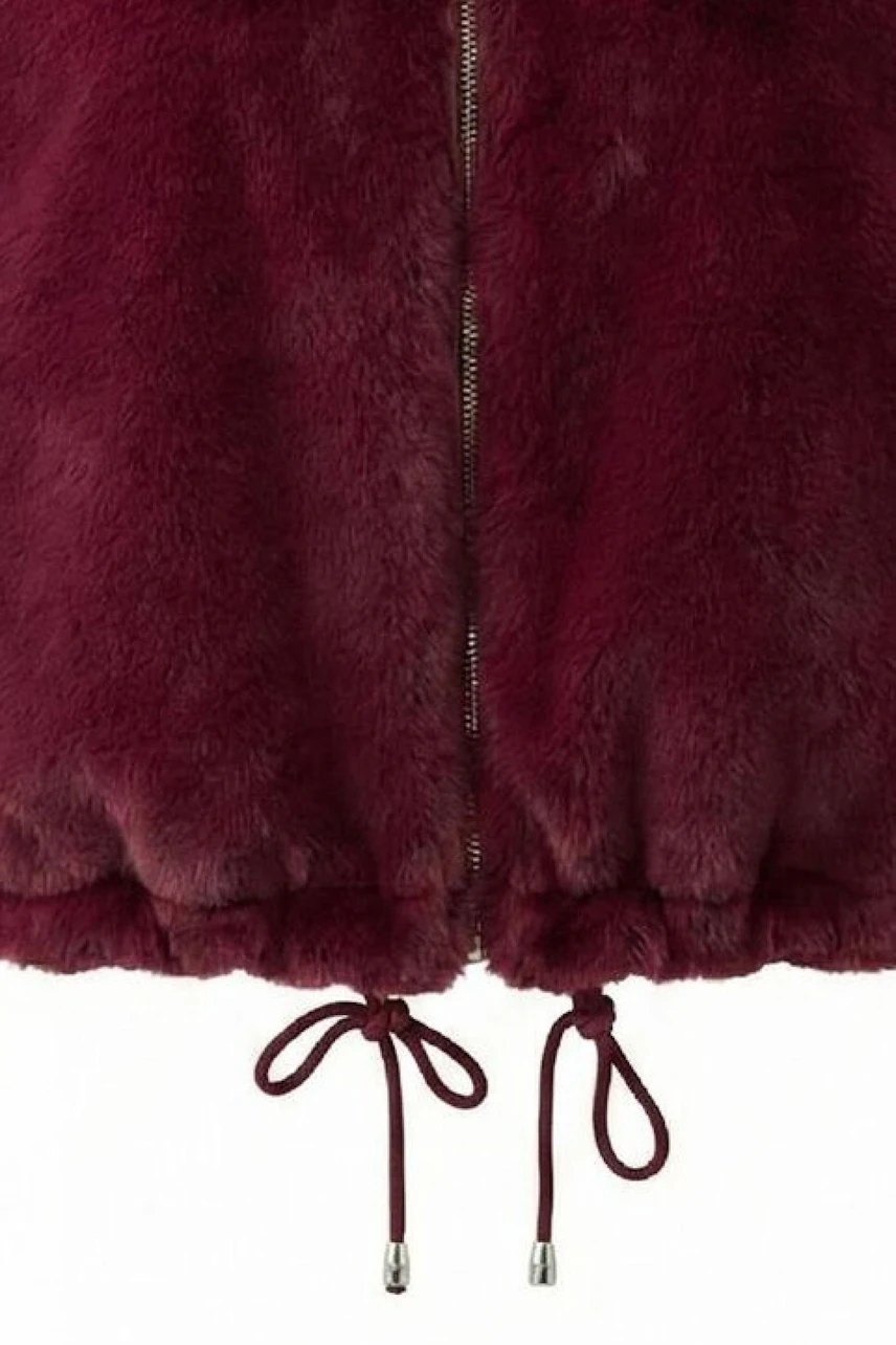 Plush burgundy vest with drawstrings and zipper, perfect for layering in cooler weather.