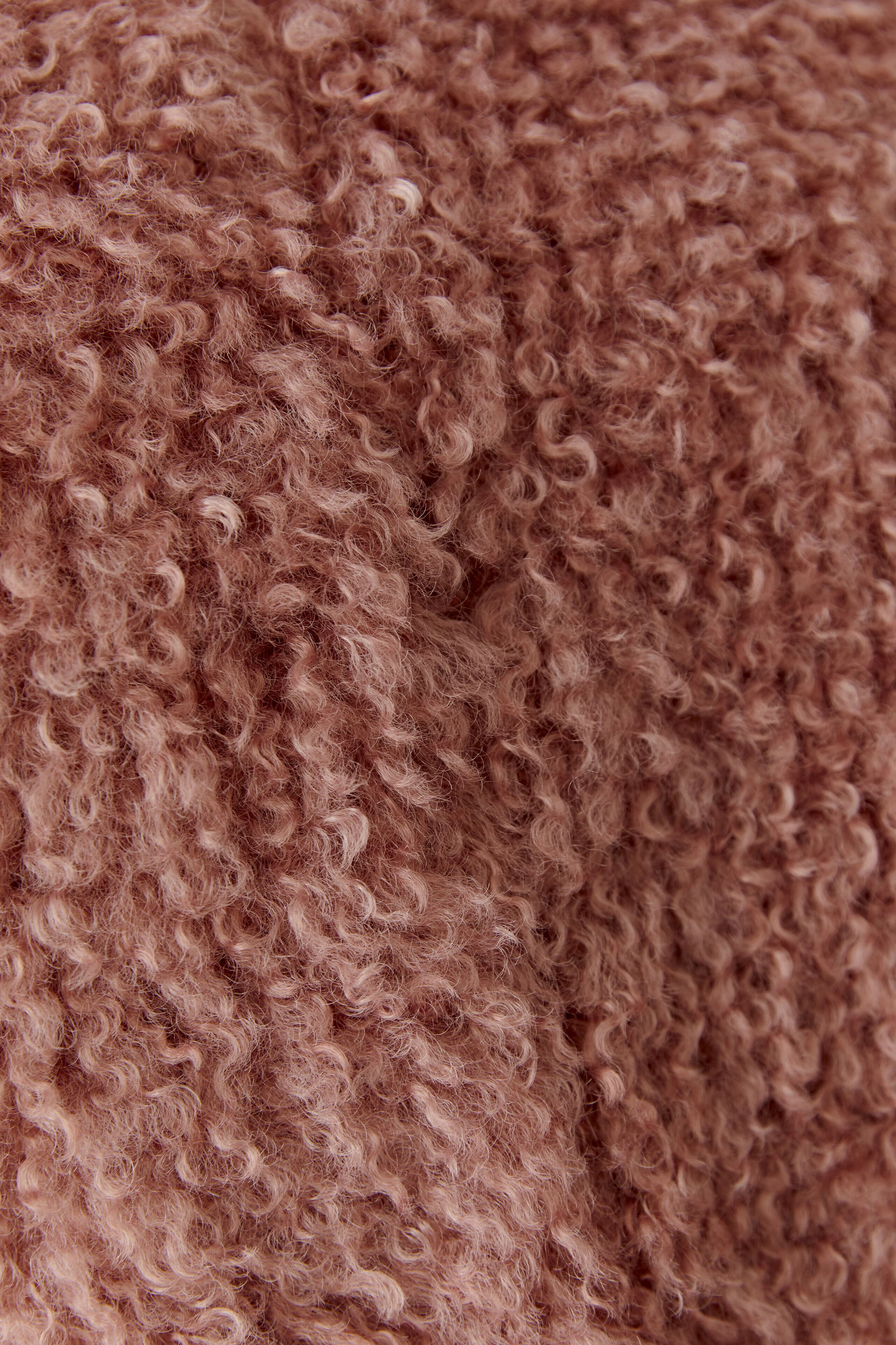 Kuschelige Damen-Weste aus weichem, strukturiertem Stoff in warmem Rosa. Ideal für gemütliche Tage.