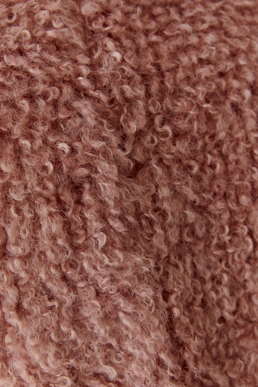 Kuschelige Damen-Weste aus weichem, strukturiertem Stoff in warmem Rosa. Ideal für gemütliche Tage.