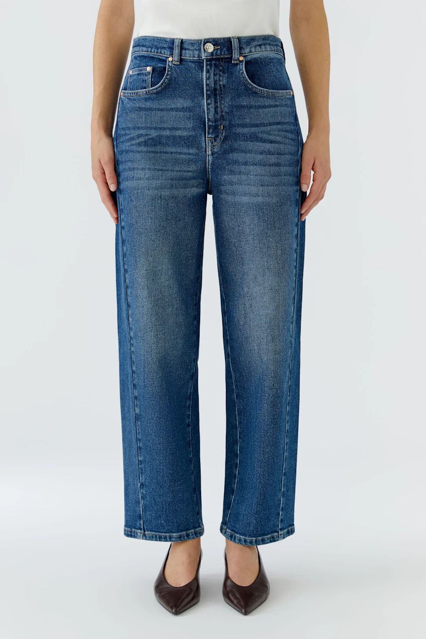 Jeans Barrel: Frau in blauer Barrel-Jeans, gerade geschnitten, mit hohem Bund und klassischem 5-Pocket-Design.