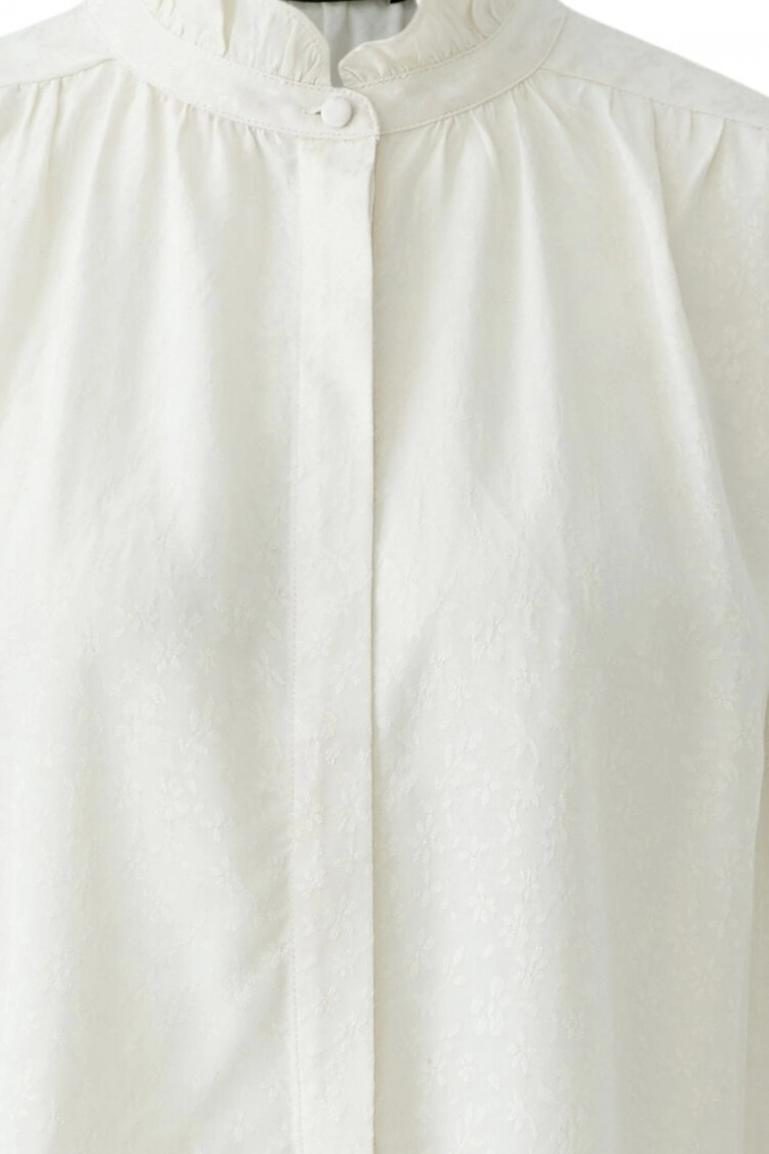 Weiße Damen-Bluse mit dezentem Muster und Stehkragen, ohne Model abgebildet.