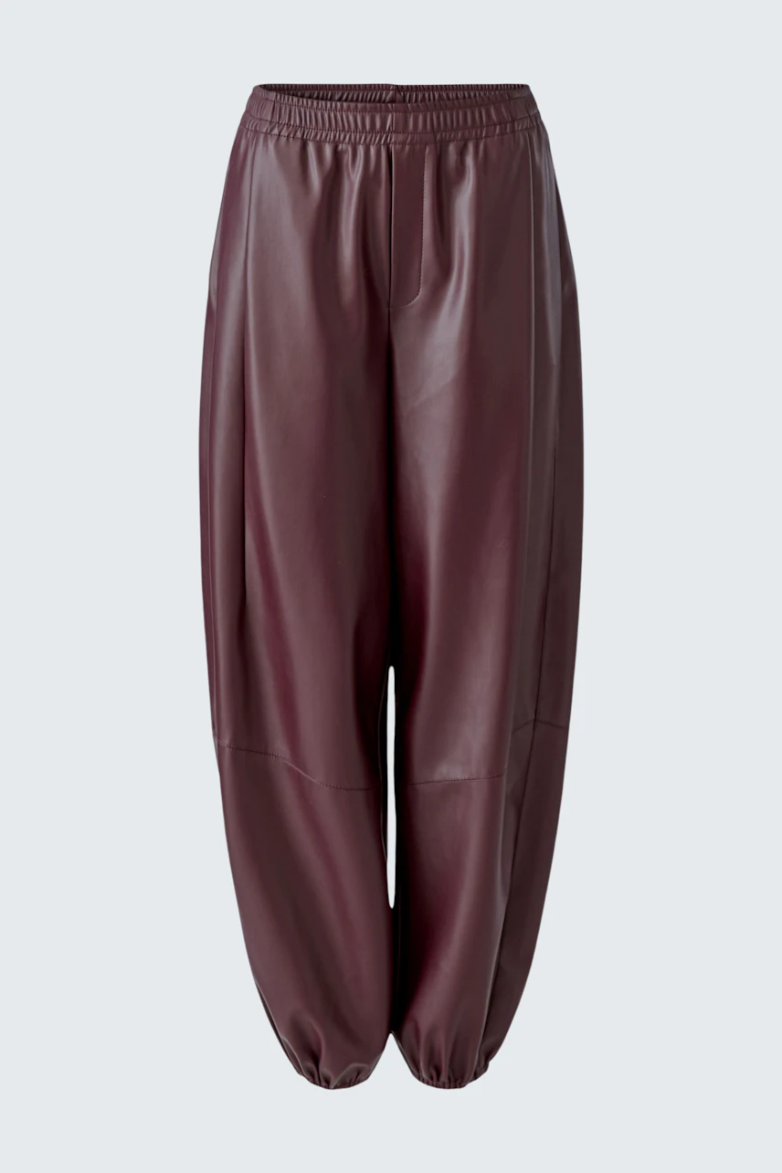 Lederimitathose in Dunkelrot: Locker geschnittene Hose mit elastischem Bund und Bündchen, ohne Model.
