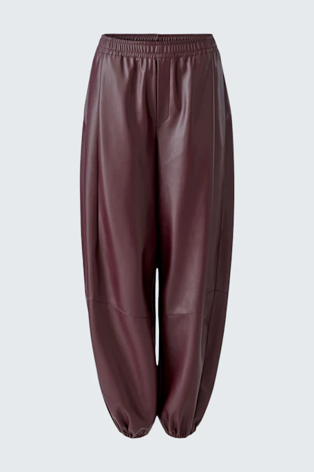 Lederimitathose in Dunkelrot: Locker geschnittene Hose mit elastischem Bund und Bündchen, ohne Model.